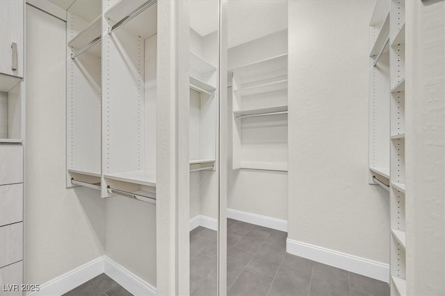 spacious closet featuring dark tile patterned flooring