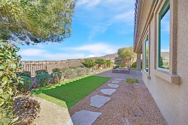 view of yard with a fenced backyard, a mountain view, and a patio