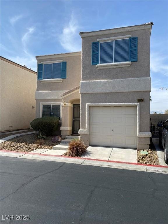 view of front of house featuring concrete driveway, an attached garage, and stucco siding