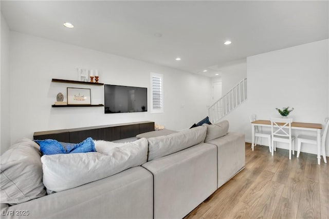 living room featuring light wood finished floors, stairway, and recessed lighting