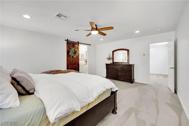 bedroom with recessed lighting, a barn door, visible vents, and light colored carpet