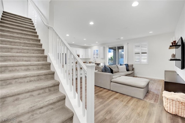 staircase with recessed lighting, baseboards, and wood finished floors