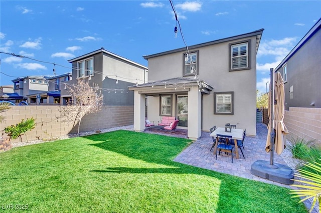 rear view of house featuring a lawn, a patio area, a fenced backyard, and stucco siding