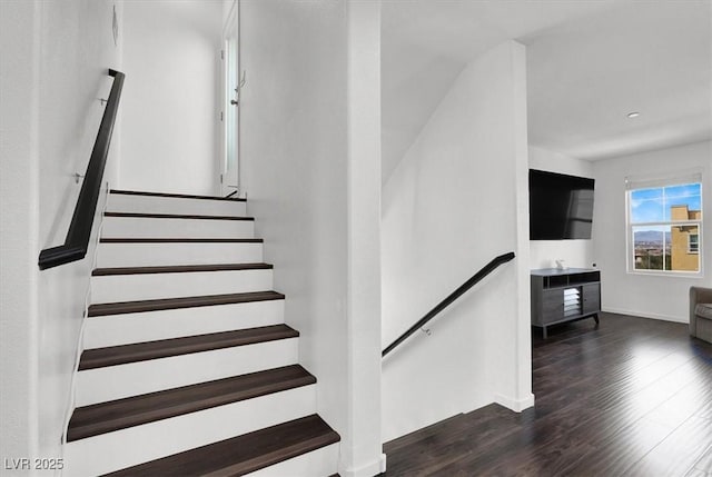 staircase featuring baseboards and wood finished floors