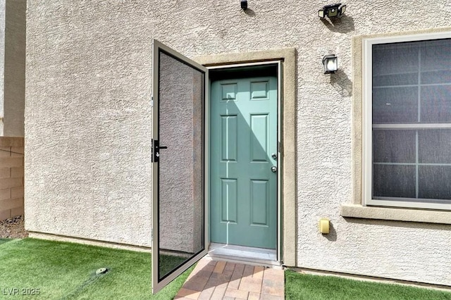 entrance to property featuring stucco siding