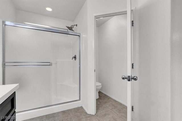 bathroom with a stall shower, tile patterned flooring, vanity, and toilet