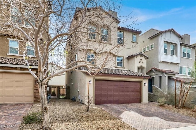 view of property featuring a garage, decorative driveway, and stucco siding