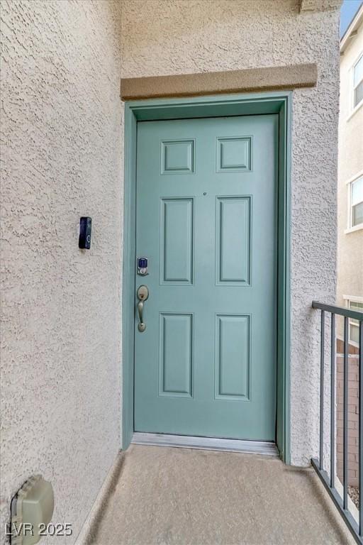 doorway to property with a balcony and stucco siding