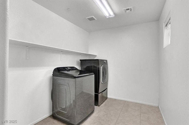 washroom with washing machine and dryer, laundry area, visible vents, and baseboards