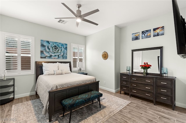 bedroom with light wood-type flooring, visible vents, and baseboards