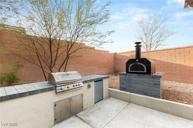 view of patio / terrace featuring area for grilling, a fenced backyard, and grilling area