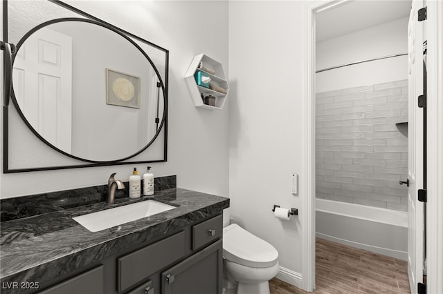 full bath with vanity, wood finished floors, baseboards, toilet, and shower / bathtub combination