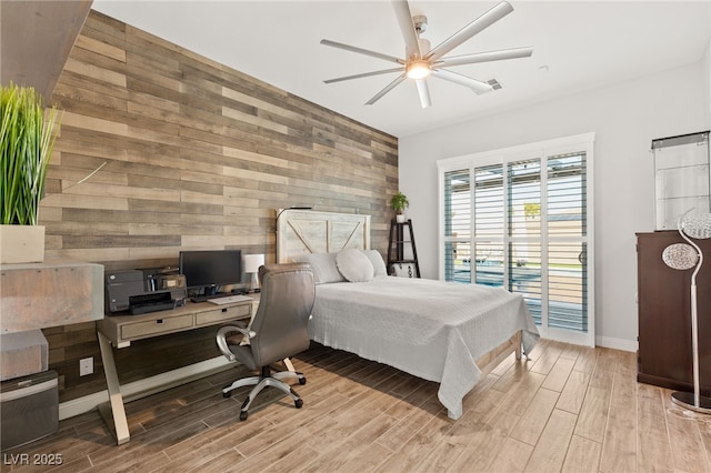 bedroom with access to outside, wood walls, an accent wall, and wood tiled floor