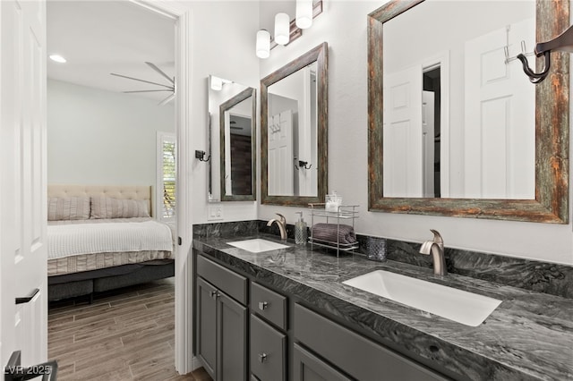 full bathroom with double vanity, ensuite bathroom, wood tiled floor, and a sink