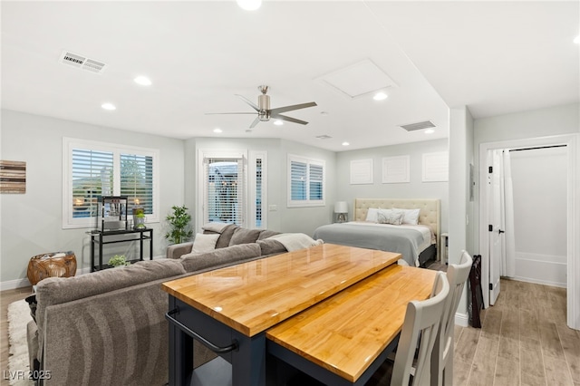 bedroom with light wood finished floors, visible vents, recessed lighting, and baseboards