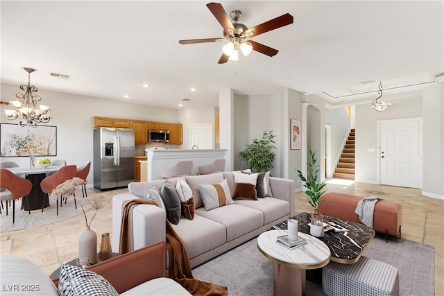 living room featuring recessed lighting, ceiling fan with notable chandelier, visible vents, baseboards, and stairway