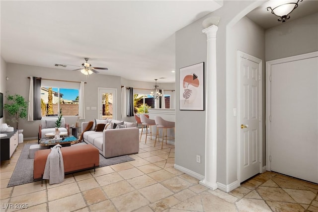 living area with plenty of natural light, decorative columns, visible vents, and ceiling fan with notable chandelier