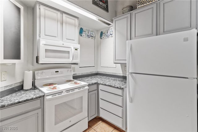 kitchen featuring light tile patterned floors, light countertops, and white appliances