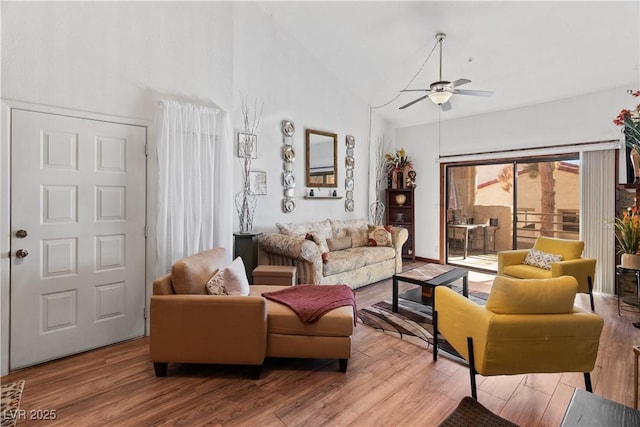 living room with a ceiling fan, high vaulted ceiling, and wood finished floors