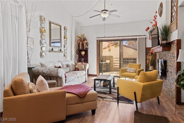 living room featuring a brick fireplace, ceiling fan, and wood finished floors