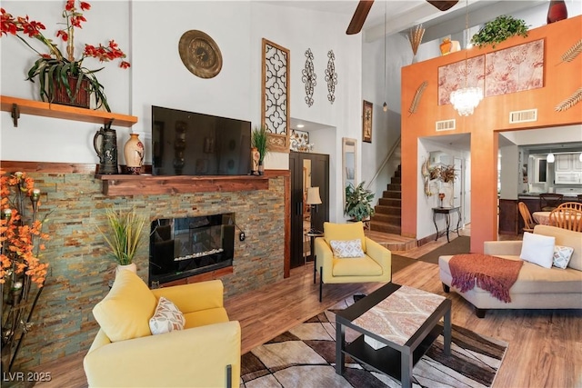 living room with stairway, a fireplace, wood finished floors, and visible vents