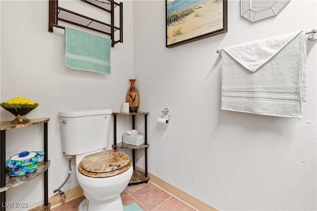 half bathroom featuring baseboards, toilet, and tile patterned floors