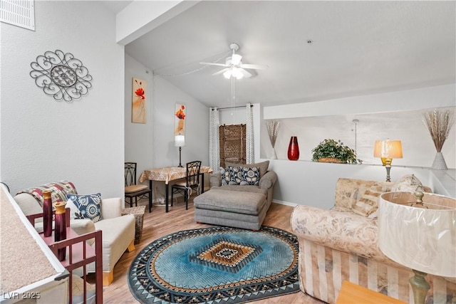 living area with lofted ceiling, ceiling fan, wood finished floors, and visible vents