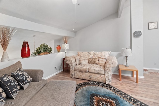 living area with vaulted ceiling with beams, light wood finished floors, and baseboards