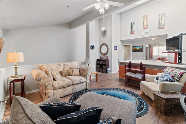 living room featuring baseboards, visible vents, ceiling fan, wood finished floors, and high vaulted ceiling