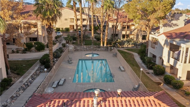 view of swimming pool featuring a hot tub and a residential view