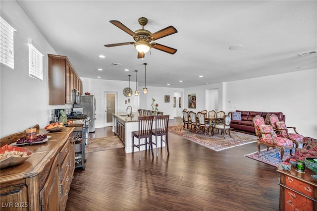 interior space featuring dark wood finished floors, visible vents, appliances with stainless steel finishes, open floor plan, and a sink