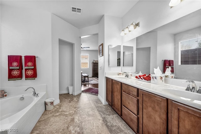 full bath featuring a garden tub, double vanity, a sink, and visible vents