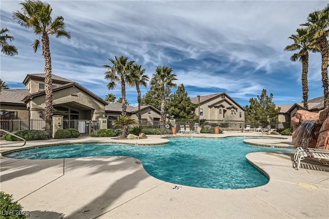 community pool featuring a residential view, fence, and a patio