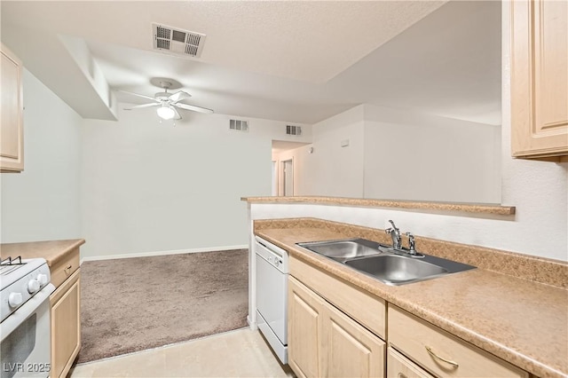 kitchen featuring white appliances, visible vents, light countertops, light brown cabinets, and a sink