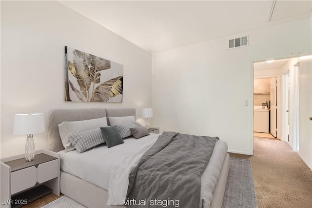 bedroom with light carpet, visible vents, and washer / clothes dryer