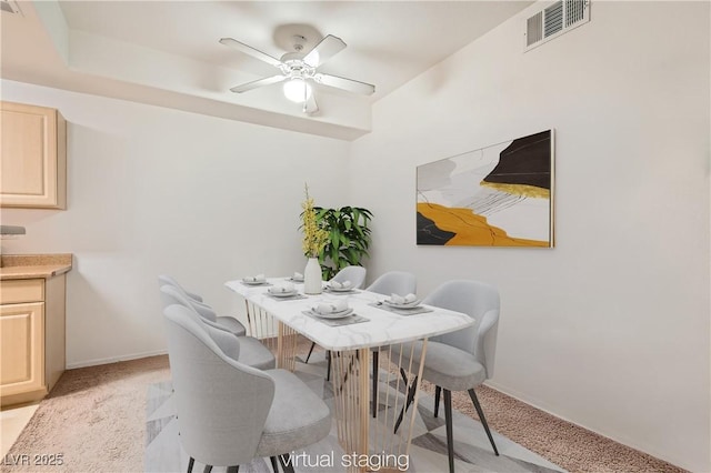 dining area featuring light carpet, baseboards, visible vents, and a ceiling fan