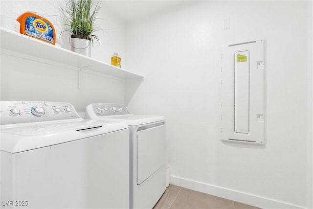 laundry room featuring washing machine and clothes dryer, light tile patterned floors, laundry area, electric panel, and baseboards