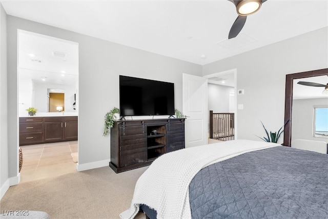 bedroom featuring a ceiling fan, light colored carpet, baseboards, and ensuite bathroom