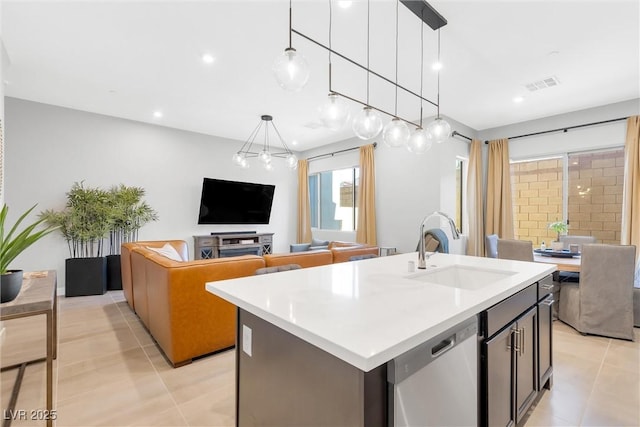 kitchen with a center island with sink, open floor plan, decorative light fixtures, stainless steel dishwasher, and a sink