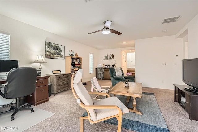 office with a ceiling fan, light colored carpet, and visible vents