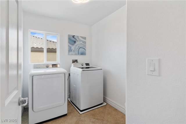 clothes washing area featuring washing machine and dryer, laundry area, and baseboards