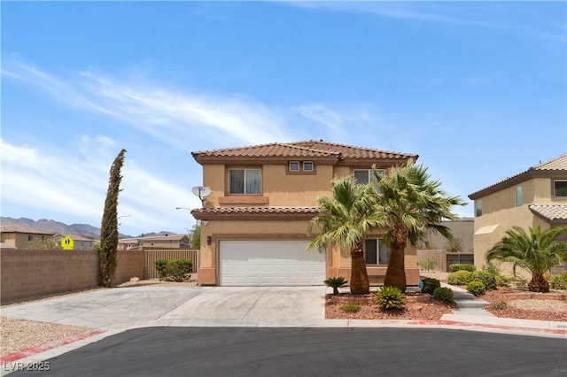 mediterranean / spanish-style home featuring concrete driveway, an attached garage, fence, and stucco siding