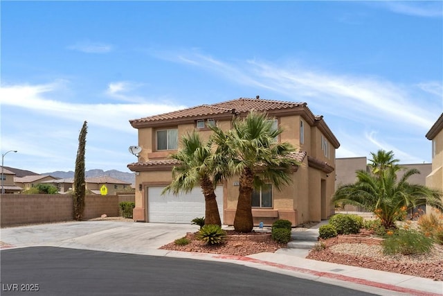 mediterranean / spanish home with stucco siding, an attached garage, fence, driveway, and a tiled roof