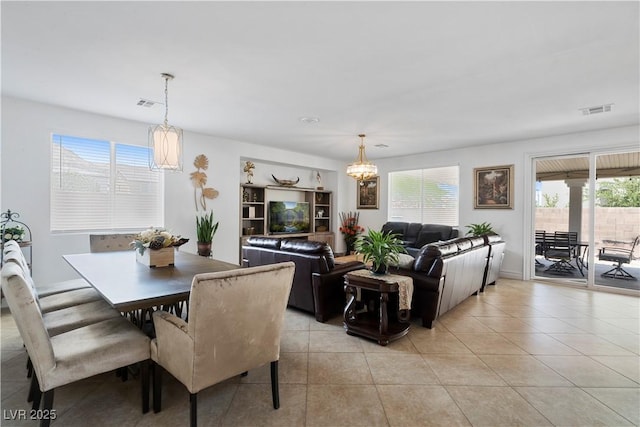 dining room featuring light tile patterned floors, visible vents, and an inviting chandelier