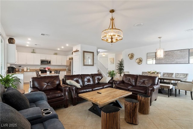 living area featuring light tile patterned floors, recessed lighting, visible vents, stairway, and an inviting chandelier