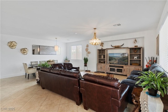 living room featuring visible vents, a notable chandelier, baseboards, and light tile patterned floors