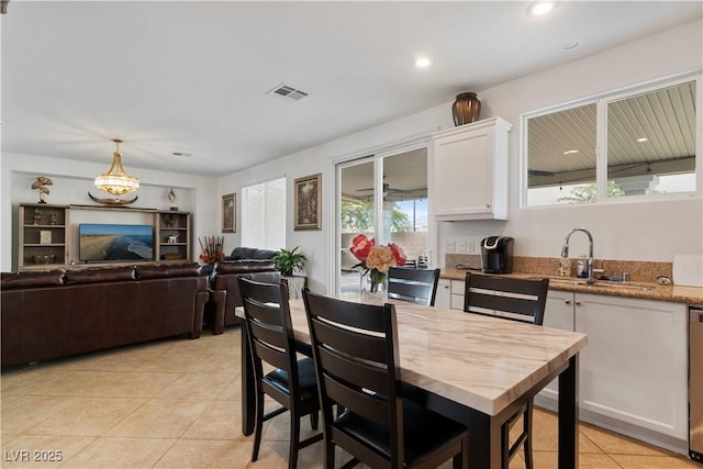 kitchen featuring light tile patterned floors, visible vents, open floor plan, white cabinetry, and pendant lighting