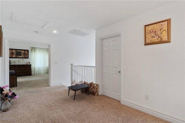 interior space featuring light carpet, baseboards, visible vents, and attic access