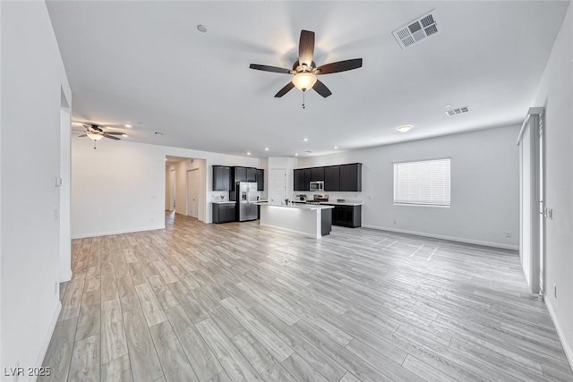 unfurnished living room with ceiling fan, light wood-type flooring, visible vents, and baseboards