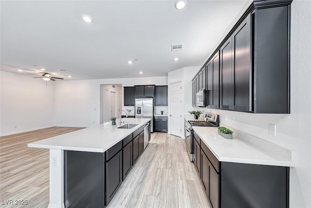 kitchen featuring light countertops, appliances with stainless steel finishes, a sink, and visible vents